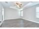 Light-filled main bedroom features tray ceiling with ceiling fan, and wood-look floors at 1210 Harbour Blue St, Ruskin, FL 33570