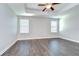 Open main bedroom featuring a tray ceiling with ceiling fan, neutral paint and wood-look floors at 1210 Harbour Blue St, Ruskin, FL 33570