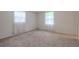 Empty bedroom with two windows and carpet flooring at 12220 Twin Branch Acres Rd, Tampa, FL 33626