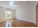 Bedroom with hardwood floors, closet, and natural light streaming through the window at 12220 Twin Branch Acres Rd, Tampa, FL 33626