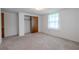 Bright bedroom with neutral carpet, closet, and natural light from the large window at 12220 Twin Branch Acres Rd, Tampa, FL 33626