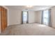 Spacious bedroom with carpet floors and two windows with curtain coverings at 12220 Twin Branch Acres Rd, Tampa, FL 33626