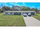 Charming home featuring a well-manicured lawn, a long driveway, and an inviting front porch seating area at 12220 Twin Branch Acres Rd, Tampa, FL 33626