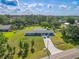 A bright home with a long driveway, attached garage, and well-manicured lawn with mature trees at 12220 Twin Branch Acres Rd, Tampa, FL 33626