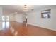 Large living area with wood floors and a kitchen view through a cut-out window at 12220 Twin Branch Acres Rd, Tampa, FL 33626