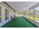 Screened-in porch perfect for outdoor relaxation with seating and green turf at 12220 Twin Branch Acres Rd, Tampa, FL 33626