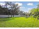 A sunny backyard with a lush green lawn and a white fence at 125 Hidden Estates Ct, Brandon, FL 33511