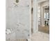 Elegant bathroom features marble tile, glass shower, and seamless transition into the living space at 125 Hidden Estates Ct, Brandon, FL 33511