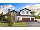 Charming two-story home featuring mixed stone and stucco, a three-car garage, and beautifully landscaped front yard at 125 Hidden Estates Ct, Brandon, FL 33511