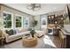 Living room with large windows, wet bar with cabinets, and plush seating area with accent pillows at 125 Hidden Estates Ct, Brandon, FL 33511