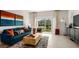 Inviting living room featuring a comfortable blue sofa and sliding glass doors to the outdoor patio at 14040 Textile Run, Parrish, FL 34219