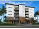 Modern condo building featuring stone accents, covered parking, and the name Beach Flower on the building at 14048 Gulf Blvd # 201, Madeira Beach, FL 33708