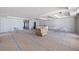 Large unfinished room featuring blue tape on the floor, boxes, chairs, and a table in a bright, open space at 14048 Gulf Blvd # 201, Madeira Beach, FL 33708
