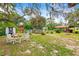 Spacious backyard with an in-ground pool, deck, seating, and several storage sheds at 14339 Mayer Ave, Hudson, FL 34669
