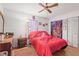 Comfortable bedroom features a ceiling fan, wood floors, and a closet with mirrored doors at 14339 Mayer Ave, Hudson, FL 34669
