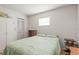 This cozy bedroom includes a bed, wood-look floors, a ceiling fan, and natural light at 14339 Mayer Ave, Hudson, FL 34669