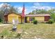 Charming single-Gathering home featuring a well-maintained lawn and an American flag in the front yard at 14339 Mayer Ave, Hudson, FL 34669
