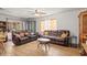 The comfortable living room features two leather sofas, wood-look flooring, and plenty of natural light at 14339 Mayer Ave, Hudson, FL 34669
