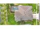Aerial view of a home with a screened-in pool, well-maintained roof, and lush landscaping at 1443 Obear Ct, Wesley Chapel, FL 33543