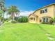 Sprawling backyard with lush green grass and tropical landscaping leading up to the house at 1443 Obear Ct, Wesley Chapel, FL 33543