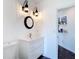 Stylish bathroom featuring a modern vanity, unique lighting fixtures and wood-look floors at 1443 Obear Ct, Wesley Chapel, FL 33543