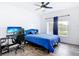 Modern bedroom with wood-look floors, ceiling fan, and a blue upholstered headboard at 1443 Obear Ct, Wesley Chapel, FL 33543