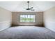 Spacious room with carpet, a ceiling fan, and a large window with a backyard view at 1443 Obear Ct, Wesley Chapel, FL 33543
