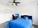 Modern bedroom with wood-look floors, ceiling fan, and a blue upholstered headboard at 1443 Obear Ct, Wesley Chapel, FL 33543