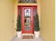 Eye-catching red front door framed by decorative trees at 1443 Obear Ct, Wesley Chapel, FL 33543