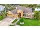 Stunning home with lush lawn, palm trees, and a vibrant red front door, next to the lake at 1443 Obear Ct, Wesley Chapel, FL 33543