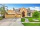 Inviting single-story home features a three-car garage, red front door, and manicured landscaping at 1443 Obear Ct, Wesley Chapel, FL 33543
