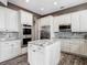 Well-equipped kitchen features granite countertops, stainless steel appliances, and custom white cabinets at 1443 Obear Ct, Wesley Chapel, FL 33543