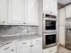 Close-up of the modern, gourmet kitchen showing a stainless double oven and custom cabinets at 1443 Obear Ct, Wesley Chapel, FL 33543
