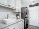 Modern laundry room with a stackable washer and dryer, custom cabinets, and granite countertops at 1443 Obear Ct, Wesley Chapel, FL 33543