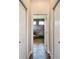 Hallway view through open door to primary bathroom with double doors and wood-look tiled flooring at 1443 Obear Ct, Wesley Chapel, FL 33543
