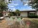 Charming home with a well-manicured lawn and tropical landscaping, enhanced with whimsical jockey-themed decorations at 1559 San Roy Dr, Dunedin, FL 34698