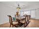 Inviting dining area with natural light, a wood table set for six, and classic chandelier lighting at 1598 Brookside Blvd, Largo, FL 33770