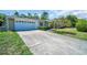 Single-story home showing a two-car garage, beautiful landscaping, and an expansive driveway at 1598 Brookside Blvd, Largo, FL 33770