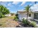 Landscaped home exterior with mature trees, shrubs, and well maintained lawn at 1598 Brookside Blvd, Largo, FL 33770