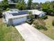 Inviting single-story home featuring a two-car garage, solar panels, and lush front lawn with tasteful landscaping at 1598 Brookside Blvd, Largo, FL 33770