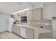 Kitchen with neutral-colored cabinets, white appliances and recessed lighting at 1598 Brookside Blvd, Largo, FL 33770