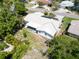 Aerial view of the house's back exterior featuring a covered patio and a yard surrounded by lush foliage at 1598 Brookside Blvd, Largo, FL 33770