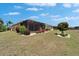 Expansive backyard with lush lawn, screened patio, landscaping, and blue skies with scattered clouds at 1643 Emerald Dunes Dr, Sun City Center, FL 33573