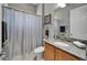 Cozy bathroom featuring a granite countertop vanity, framed mirror, shower with curtain, and tile floors at 1643 Emerald Dunes Dr, Sun City Center, FL 33573
