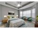 Cozy bedroom features tray ceilings and serene light from large windows, complemented by stylish decor at 1643 Emerald Dunes Dr, Sun City Center, FL 33573