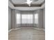 Bright bedroom with stylish tray ceiling, modern fan, and large bay windows at 1643 Emerald Dunes Dr, Sun City Center, FL 33573