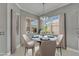 Elegant dining room featuring a round glass table and four chairs with sun-filled views from three windows at 1643 Emerald Dunes Dr, Sun City Center, FL 33573