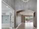 Inviting hallway featuring an arched entryway, neutral paint, tile floors, and access to other rooms at 1643 Emerald Dunes Dr, Sun City Center, FL 33573