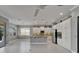 Open-concept kitchen featuring stainless steel appliances, granite countertops, white cabinets, and seamless living room access at 1643 Emerald Dunes Dr, Sun City Center, FL 33573