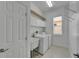 Bright laundry room with white cabinets, a utility sink, washer and dryer, and tiled floors at 1643 Emerald Dunes Dr, Sun City Center, FL 33573